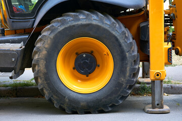 Obraz premium Lifting machine truck crane stands on stops, a large wheel of a tractor