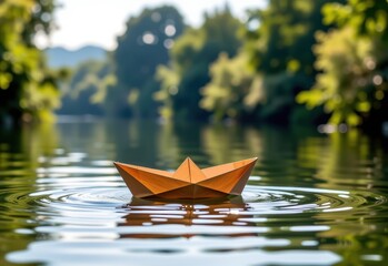 Fototapeta premium A paper boat floats serenely on a calm river bathed in the warm glow of the setting sun. Sunlight filters through the lush green foliage of trees lining the riverbank