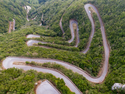 Aerial view of a winding mountain road snaking through lush green foliage in sokraki village,Corfu greece