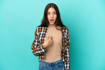 Young French woman isolated on blue background with surprise facial expression