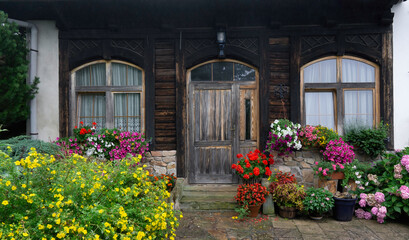 The entrance door is surrounded by blooming flowers.