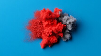 Abstract Color Study: A minimalist composition showcasing a splash of vibrant red and gray powder on a bold blue background. The colors dance and blend.