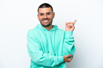 Young caucasian man isolated on white background happy and pointing up