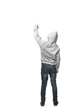 Person wearing a gray hoodie and dark pants holding an object, standing with back turned. Isolated on white background. Concept of urban lifestyle