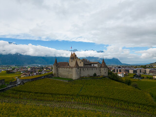 Vue aérienne panoramique du château d’Aigle, fort médiéval historique dans une vallée de montagne et collines de vignes, Vaud, Alpes, Suisse, Europe
