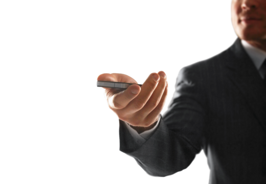 Outstretched hand of a businessman holding a remote control in focus, dressed in a suit. Isolated on a clean white background. Concept of control