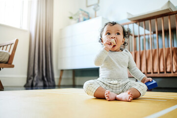 Naklejka premium Child development, toys and a baby sitting on the floor in its bedroom at home while playing or looking curious. Children, learning and growth with an adorable little girl kid in a house to play