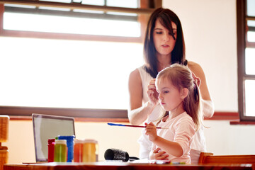 Art, creative or painting with girl and mom in home together for education or learning. Family, homework and study with woman braiding hair of daughter at desk in bedroom of apartment for bonding