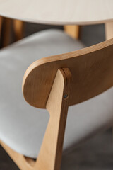 Close-up of a chair back against a plywood table in an apartment interior. Minimalism.