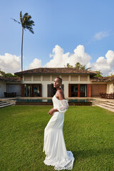 Ambiguous gender fluid person in white bridal dress at villa garden. Elegant wedding shot. LGBTQ...