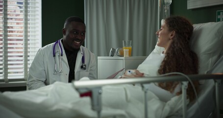 Doctor reviews the patient's chart while they talk.