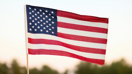 Obraz premium Waving American Flag Blowing in the Wind Against Scenic Outdoor Landscape Patriotic Symbol of Freedom Liberty and National Pride