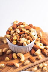 Large assortment of nuts in different bowls on stone table.