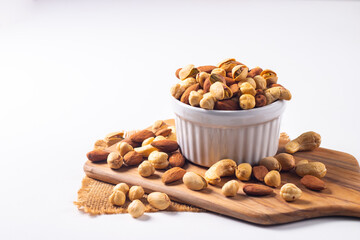 Large assortment of nuts in different bowls on stone table.