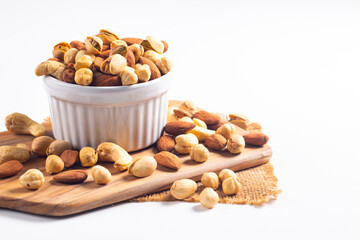Large assortment of nuts in different bowls on stone table.