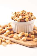 Large assortment of nuts in different bowls on stone table.