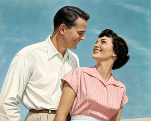 Happy couple enjoying a sunny day together in a park setting, showcasing affection and joy in their smiles