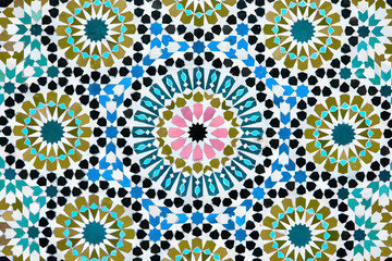 A detailed Islamic geometric mosaic featuring vibrant colors and symmetrical patterns. The design...