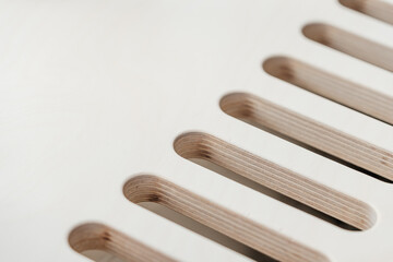 Plywood furniture. Oval holes with wood texture for apartment heating radiator.