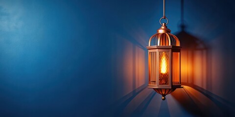 Obraz premium Illuminated Hanging Lantern Against a Deep Blue Wall, Casting a Warm Glow