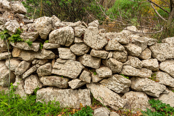 Particolare di antico muro contenitivo in campagna realizzato in pietra
