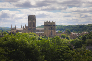 Obraz premium Durham Cathedral framed by lush green trees under a bright summer sky as seen from Wharton Park.