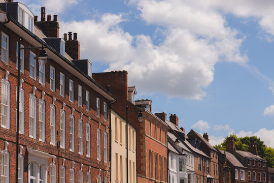Picturesque tradaitional british terraced houses with red brick facades under a sunny blue sky in Durham, England, UK.