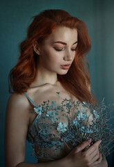 Close up portrait of sensual beautiful red haired woman with blue eyes with flowers.