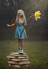A little fairy with silver hair stands on a stack of books. The girl holds a huge narcissus flower in her hands.