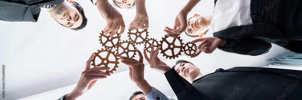 Poster below view group of multiracial business people joining gear wheels together as effective unity and 