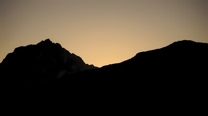 Fototapeta premium Silhouette of mountains against golden sunset sky in serene landscape. Generative AI