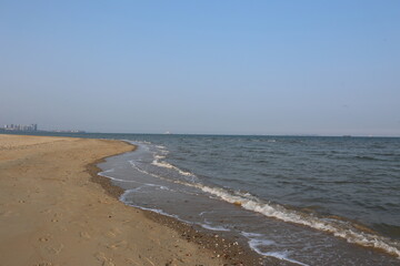 Serene Yantai Seascape: Seagulls, Rocky Coast, and Empty Sandy Beach