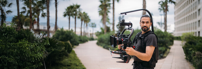 Director of photography with a camera in his hands on the set. Professional videographer at work on...