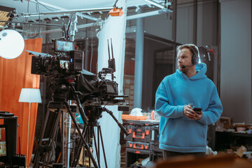 Director at work on the set. The director works with a group or with a playback while filming a movie, advertising, or a TV series. Shooting shift, equipment and group. Modern photography technique.