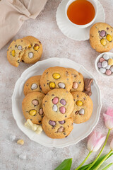 Easter cookies. Tradition american cookies with chocolate mini eggs candy on a white plate. Easter dessert. Copy space.