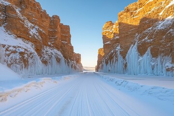 Majestic frozen canyon road surrounded by towering cliffs and icy formations during winter's light