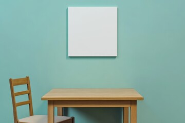 Blank canvas on teal wall above wooden table and chair. (1)