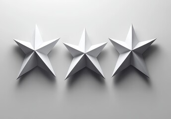 Obraz premium Three white, 3D, five-pointed stars on a light grey background.