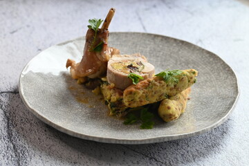 A beautifully presented plate of roasted rabbit pieces with stuffing, including a tender loin...