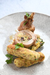 Close-up of a traditional spring dish – rabbit loin stuffed with a fragrant herb filling. The tender meat is sliced to reveal the delicious stuffing, highlighting the rustic yet elegant presentation. 