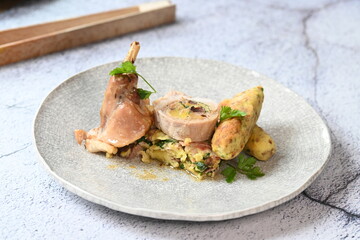 Close-up of a traditional spring dish – rabbit loin stuffed with a fragrant herb filling. The tender meat is sliced to reveal the delicious stuffing, highlighting the rustic yet elegant presentation. 