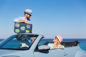 Happy couple in love travel by car by the sea