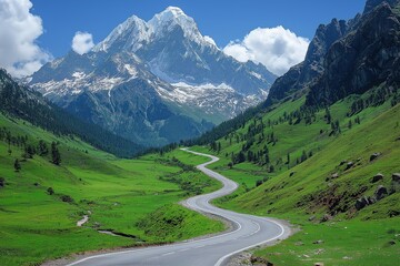 Scenic winding road through lush green fields and majestic mountains under a clear blue sky