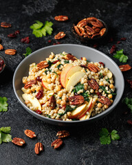 Warm barley pearl salad with kale, dried cranberries, apples and roasted pecan nuts. Healthy food