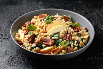 Warm barley pearl salad with kale, dried cranberries, apples and roasted pecan nuts. Healthy food