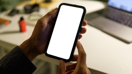 Close up of hand holding a smartphone with blank white screen for app or website mockup designs.