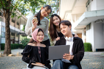 Obraz premium Group of cheerful university students standing outdoors near a campus building and discussing coursework. Education concept.
