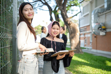 Cheerful University students sharing knowledge and ideas outdoors on campus. Education concept.