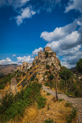 View of the church of S. Maria di Loreto in Petralia Soprana, Sicily, Italy. An avenue of trees leading to the hilltop village of Petralia Soprana in the Madonie Mountains. Long exposure. August 2024