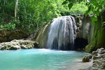 A hidden waterfall deep in the jungle, surrounded by lush green moss